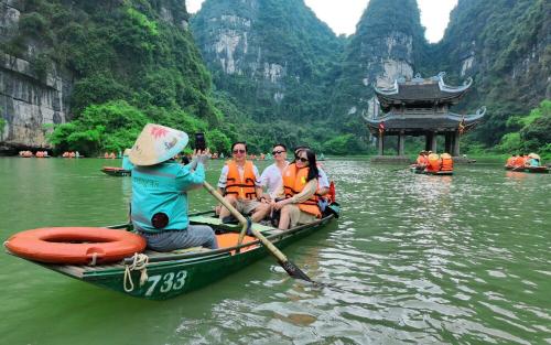 huyền chở khách tại Tràng An uốn lượn qua vách đá.